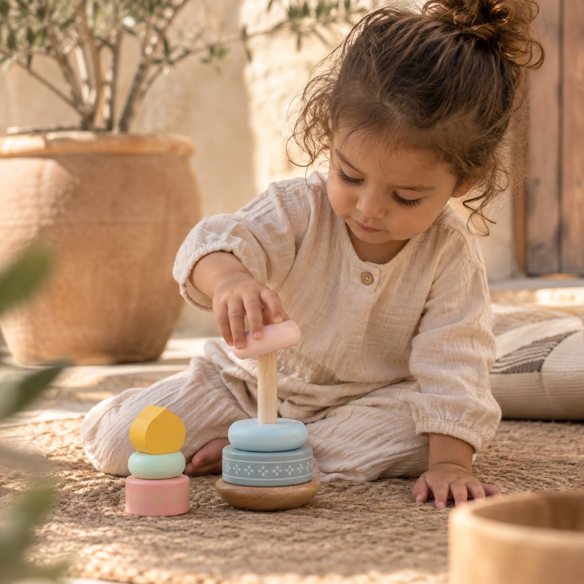 Kind speelt met pastel houten stapeltoren met moskee-elementen van Little Farah