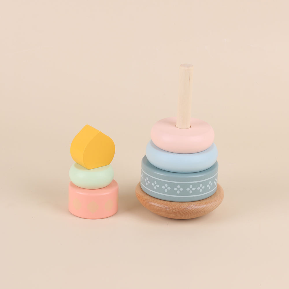 Houten stapeltoren met verticale stapelstok, pastel stapelringen op houten basis, daarnaast een kleine stapel met perzikroze basis, mintgroene ring en geel koepelvormig topstuk, montessori speelgoed voor peuters, stapelen en sorteren, motoriek en concentratie oefenen, rustige pastel uitstraling