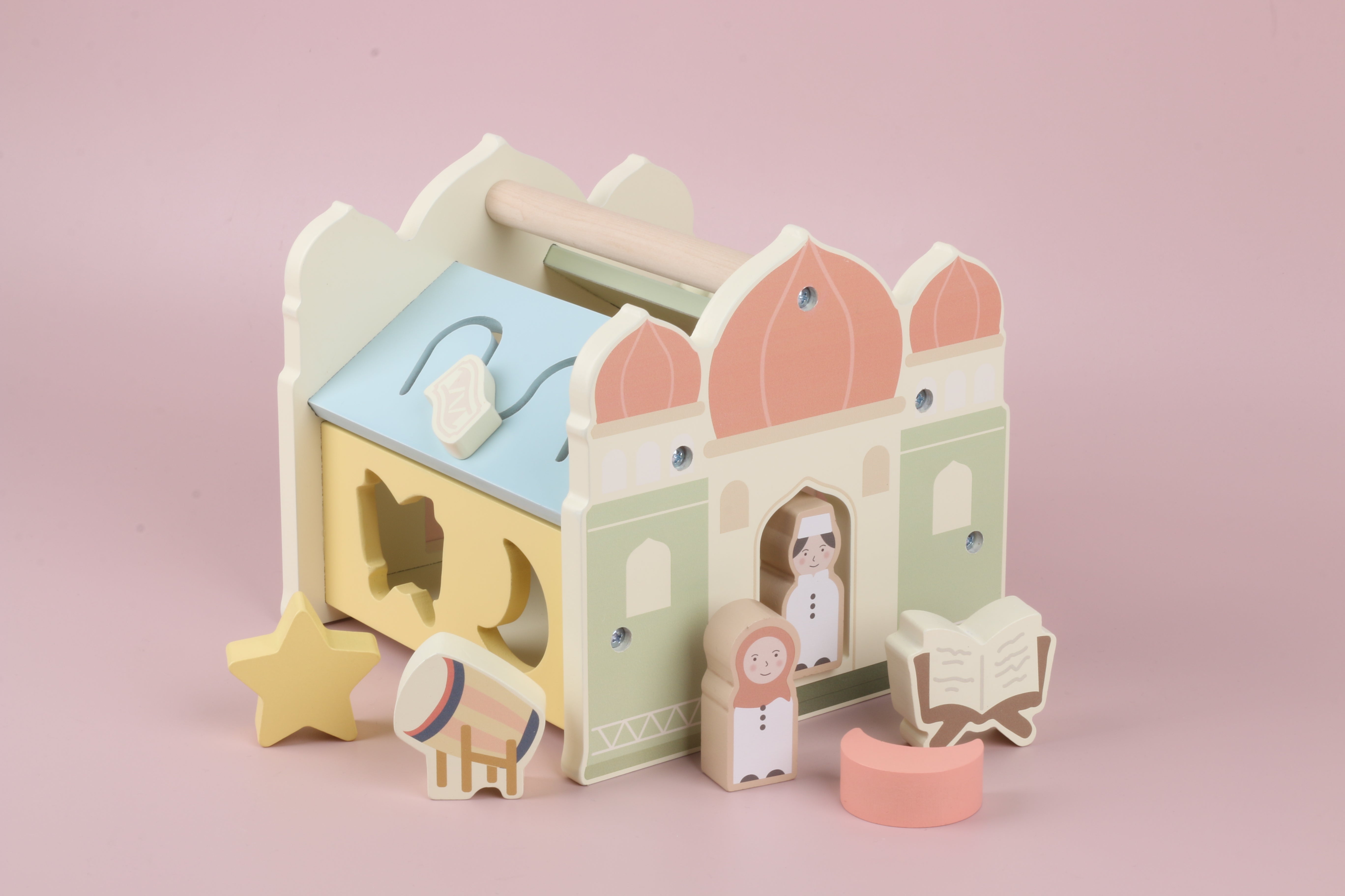 Houten masjid activiteitenkubus in pastelkleuren met islamitische sfeer, Montessori geïnspireerd motoriek speelgoed met draaghandvat, vormenstoof en verschillende speelelementen, inclusief losse figuren zoals jongen en meisje, Qur’an/boek op rihal en trommel, open-ended play dat fijne motoriek, hand-oogcoördinatie, concentratie en probleemoplossend denken stimuleert