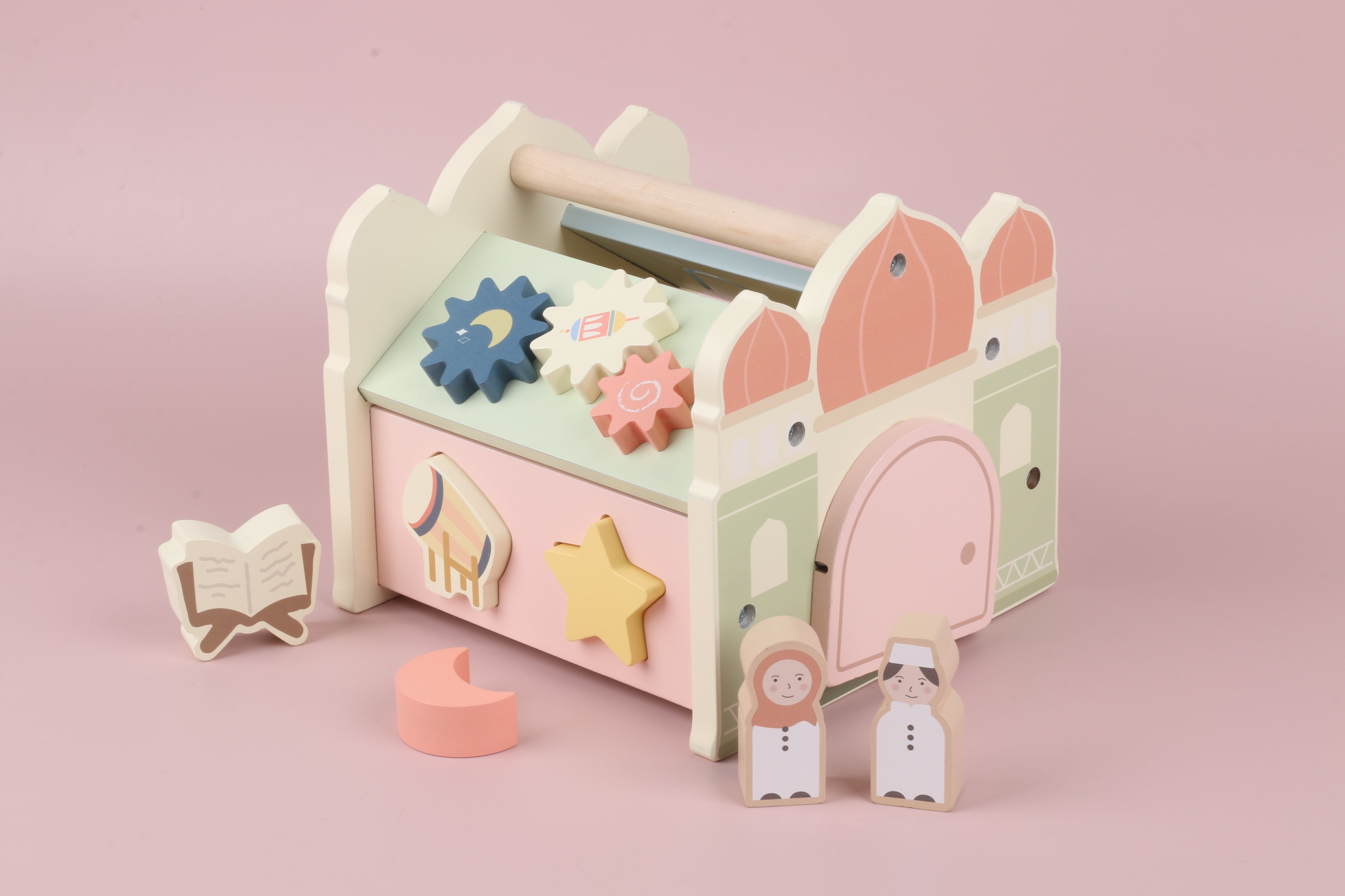 Zijaanzicht van houten masjid activity cube met vormenstoof openingen (maan en ster) en speelelementen aan de zijkant, Montessori geïnspireerd activiteitenkubus voor peuters en kleuters om te sorteren, passen en ontdekken, educatief houten speelgoed dat motoriek, ruimtelijk inzicht en zelfstandig spelen ondersteunt, subtiel islamitisch tintje door masjid ontwerp en zachte kleuren