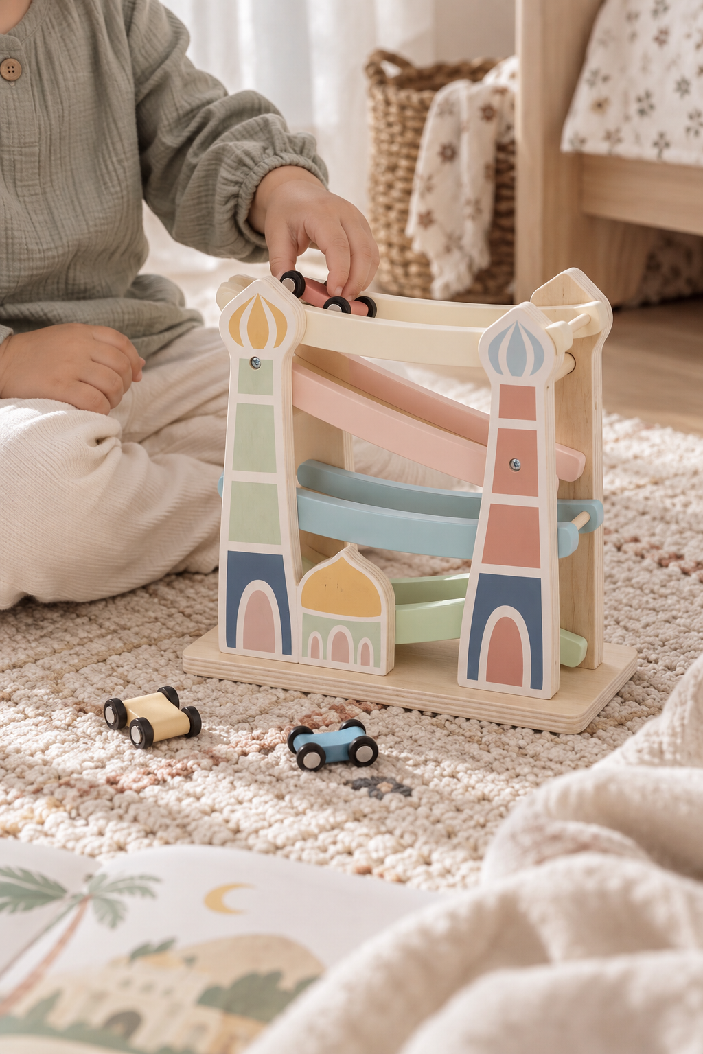 Kind speelt met de houten Masjid Racebaan van Little Farah met drie pastel speelgoedautootjes.